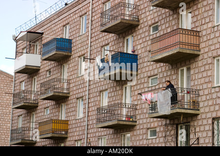Armenien Vanadzor Erwachsenen armenische Frau hängen Wäsche zum Trocknen auf Balkon des Mehrfamilienhauses mehrstöckige Ziegelbau Stockfoto
