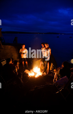 Paar genießt Lagerfeuer Thompson Lake Otisfield Maine Stockfoto