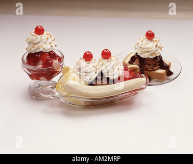 drei Glas Gerichte Bananensplit Erdbeer Eis Eisbecher Vanille Schokolade Erdbeere Ananas Kirsche Schlagsahne topping Stockfoto