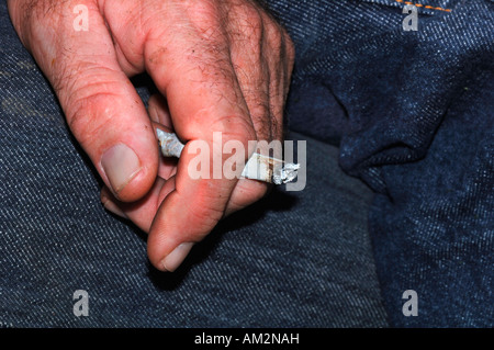 Ein Mans Hand Holding eine ungefilterte Rollup beleuchtete Zigarette Stockfoto