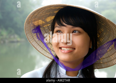 Junge vietnamesische Frau trägt traditionelle Ao Dai Kleid und konische Hut in Hue Stockfoto