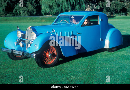 Ein Mann und eine Frau in einem blauen Bugatti Auto bei einer Oldtimer-Show in Pebble Beach Kalifornien ca 1985 Stockfoto