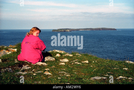 Sitzen auf den Klippen mit Blick auf Caldey Island in Pembrokeshire Wales Stockfoto