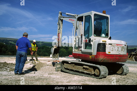 Bauherren mit mechanischen Bagger Aushub Fundamente für neue Wohnungen Stockfoto