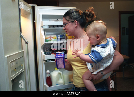 Junge Teenager Mutter kämpfen, um Essen für ihr Kind vorzubereiten. Stockfoto