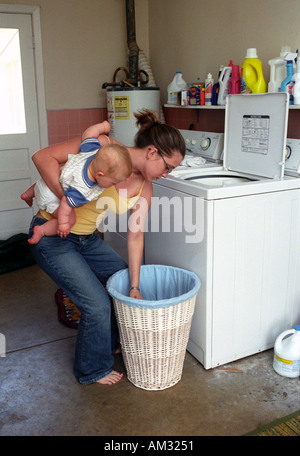 teenaged Mutter mit Kleinkind und Hausarbeit zu kämpfen. Stockfoto