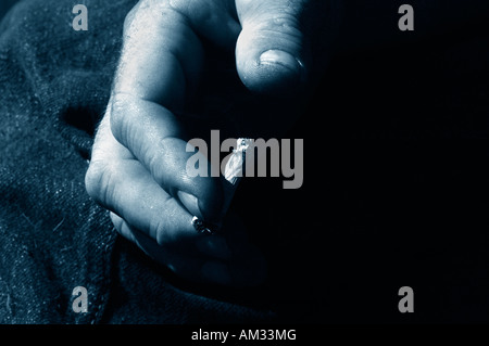 Ein Mans Hand Holding eine ungefilterte Rollup beleuchtete Zigarette Stockfoto