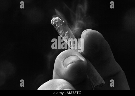 Ein Mans Hand Holding eine ungefilterte Rollup beleuchtete Zigarette Stockfoto