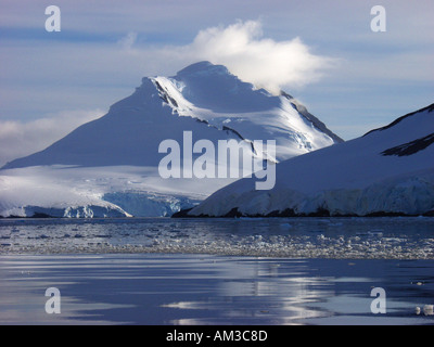 Wolken auf einem schneebedeckten Berg im Paradies Hafen aka Paradise Bay Antarctica Stockfoto