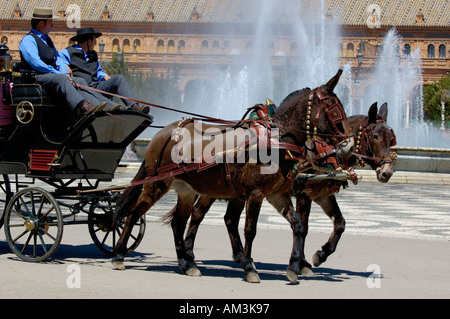 Bespannten Wagen treibende Menschen rund um die Plaza de Espana während der Feria De Abril in Sevilla, Andalusien, Spanien. Stockfoto