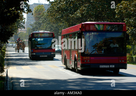 Spanien Andalusien Sevilla öffentliche Busse und eine Kalesche Beförderung während der Feria De Abril im Maria Luisa Park Stockfoto