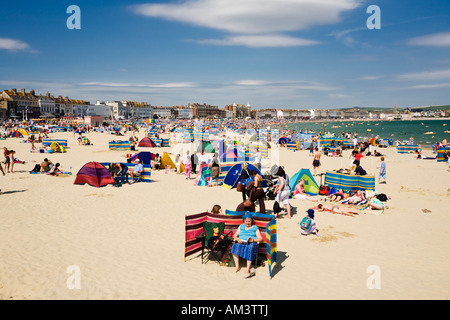 People on the crowded busy seaside beach on a hot summer day, Weymouth beach, Dorset, England, UK Stockfoto