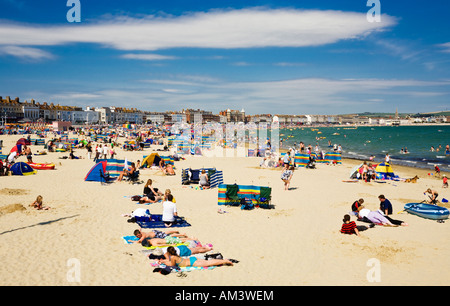 Urlauber am Strand am Meer am Strand von Weymouth, Dorset, Großbritannien, in der Sommersaison Stockfoto