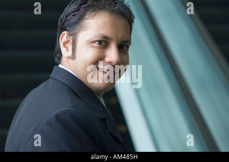 Seitenansicht eines Geschäftsmannes in der Nähe einer Rolltreppe Stockfoto