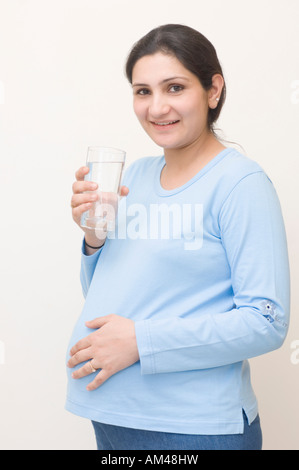 Porträt von einer schwangeren Frau Trinkwasser aus einem Glas Stockfoto