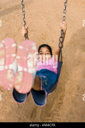 Porträt eines Mädchens auf einer Schaukel sitzend Stockfoto