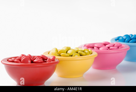 Reihe von vier Schüsseln gefüllt mit Bonbons Stockfoto
