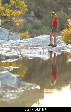 Frau steht an einem schmalen Bach in den USA Südwesten Stockfoto