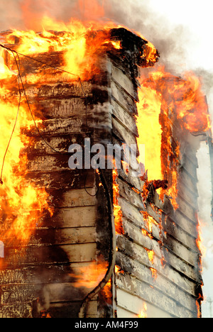Ein kleines Haus auf den Boden in ein Feuer brennen Stockfoto