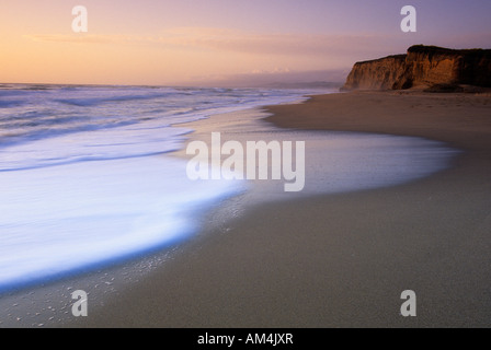 Wellen angespült am Strand bei Sonnenuntergang in Pomponio State Beach, Kalifornien, USA Stockfoto