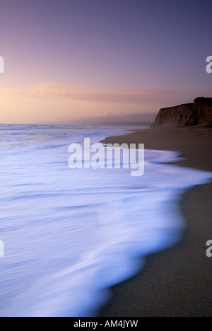 Wellen angespült am Strand bei Sonnenuntergang in Pomponio State Beach, Kalifornien, USA Stockfoto