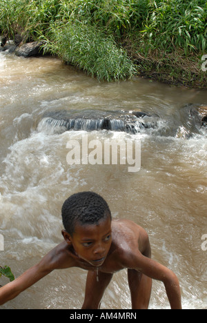 Eine äthiopische Junge klettert aus dem Fluss, die, dem er im Schwimmen. Haro, Äthiopien Stockfoto