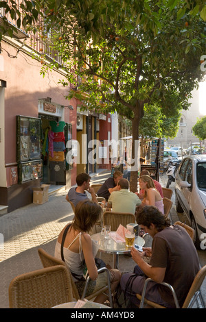 Junge Menschen vor einer Bar in der Barrio de Santa Cruz in frühen Abend in der Nähe von Kathedrale & Giralda, Sevilla, Andalusien, Spanien Stockfoto