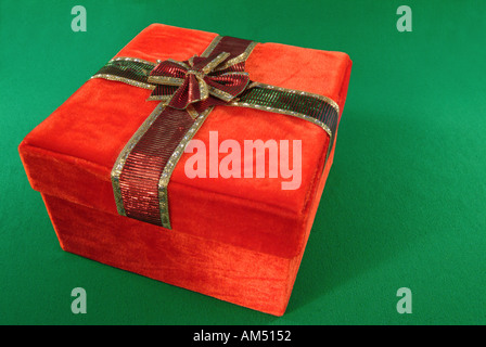 roten Geschenkbox mit Schleife und Bogen. Die Verpackung ist rot samt Stoff Stockfoto
