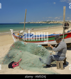 Portugal-Algarve-Fischer in Armacao de Pera ausbessern Netze am Strand Stockfoto