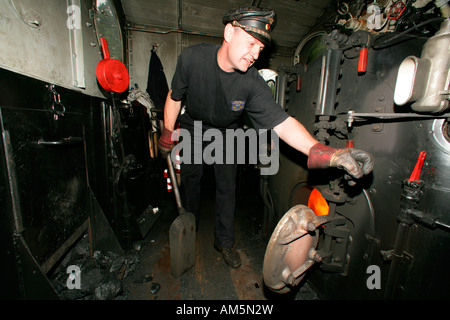 Lokführer, die Betankung des Tanks in einem historischen Dampfzug Stockfoto