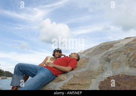 Junge Frau mit einem jungen Mann am Strand liegen und lächelnd Stockfoto