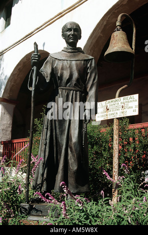 Statue eines Priesters stehend neben einer Glocke, Mission Santa Barbara, Santa Barbara, Kalifornien, USA Stockfoto