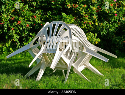 Weiße Gartenstühle, Tisch gelehnt Stockfoto