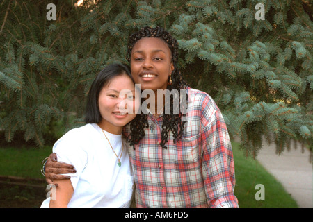 Asiatische und schwarze Freundinnen Alter 20 glücklich umarmen. St Paul Minnesota USA Stockfoto