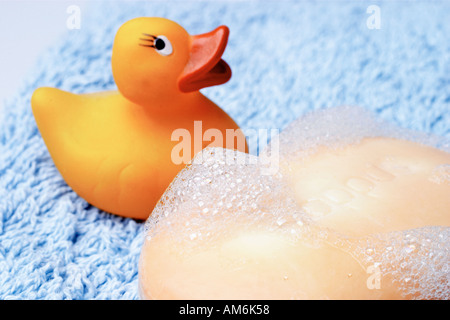 Gummiente mit Seife und Schaum auf blaues Handtuch Stockfoto