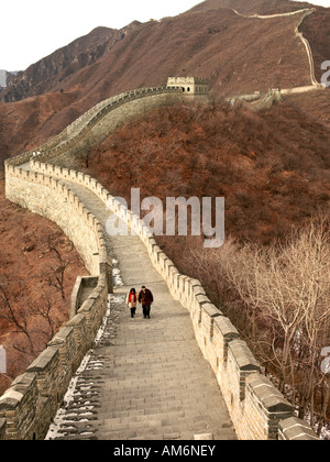 Ein paar im Wintermäntel gekleidet geht auf einem Abschnitt der chinesischen Mauer nahe Peking. Stockfoto