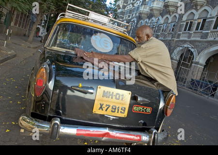 Ein indischer Taxifahrer Reinigung sein Auto vor Arbeitsbeginn von seiner Zeit in Mumbai, Indien. Stockfoto