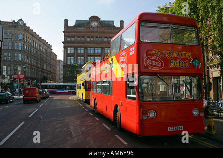 Open Top hell rot und lebendige gelb-Tourbusse warten auf Touristen im zentralen Stadtzentrum von Belfast, Northern Ireland UK GB Stockfoto