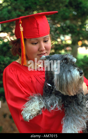 Dipl.-Mütze und Mantel Alter 18 Holding Haustier Hund. Elkhart Indiana USA Stockfoto