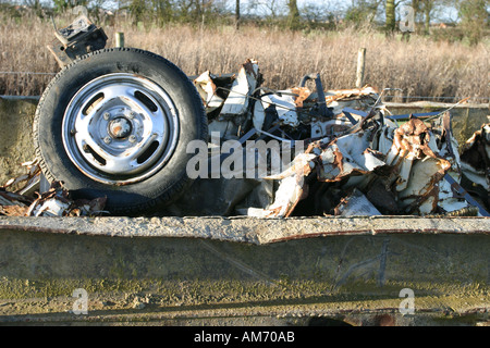 Ein Autowrack erholte sich von Brachland und in einen Müllcontainer geworfen Stockfoto