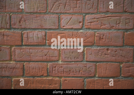 Namen, die auf alte Schule Mauer zerkratzt Stockfoto