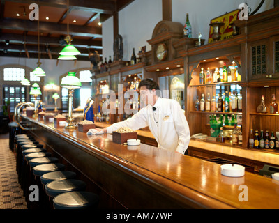 Ein Barkeeper wischt die Bar Theke im Raffles Hotel Singapore Stockfoto