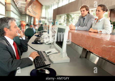Geschäftsmann mit Telefon mit Kollegen stützte sich auf Zähler Stockfoto