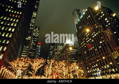 Beleuchtete Bäume vor Wolkenkratzer, 6th Avenue, Weihnachten in New York City, USA Stockfoto