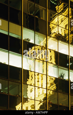 Spiegelung eines alten Hochhaus in einer modernen Glasfront, New York City, USA Stockfoto