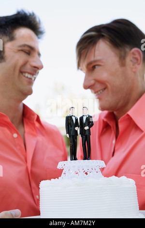 Homosexuell Brautpaar Bräutigam auf ihre Hochzeitstorte anzeigen Stockfoto