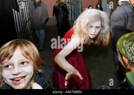 Junges Mädchen mit Hexenschminke, das nach einem Kind greift, Halloween-Veranstaltung für Kinder, Theatermuseum Düsseldorf, NRW, Deutschland Stockfoto