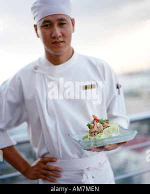 Ein vietnamesischer Koch präsentiert einen Garnelen-Salat mit jungen Mango Fetzen im Restaurant auf der Dachterrasse in Ho-Chi-Minh-Stadt-Vietnam Stockfoto