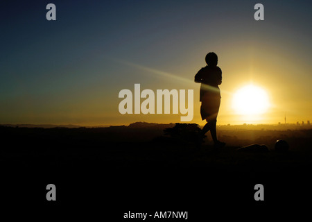 junger Mann Joggen bei Sonnenuntergang Stockfoto