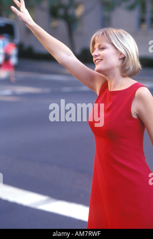 Junge Frau winken draußen unterwegs Stockfoto